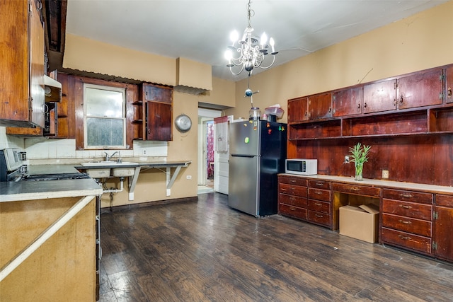 kitchen with pendant lighting, stainless steel fridge, a chandelier, exhaust hood, and dark hardwood / wood-style flooring