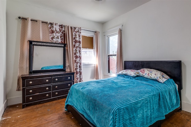 bedroom with dark hardwood / wood-style flooring