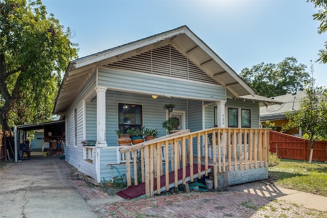 bungalow-style house featuring a porch and a carport