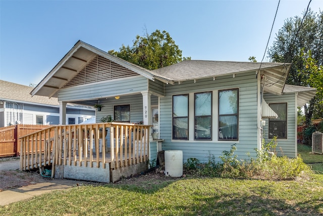 rear view of property featuring a yard and a wooden deck