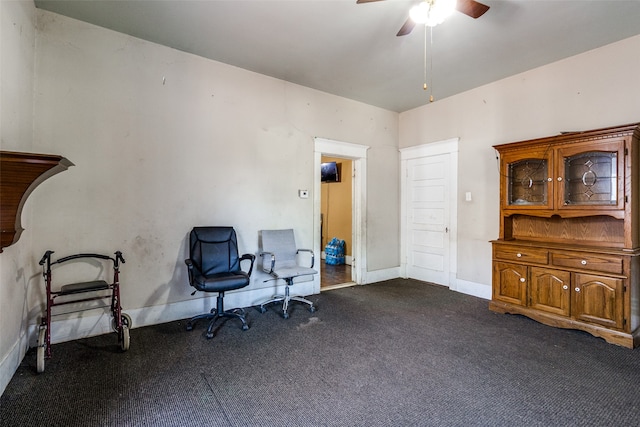 sitting room with ceiling fan and dark carpet