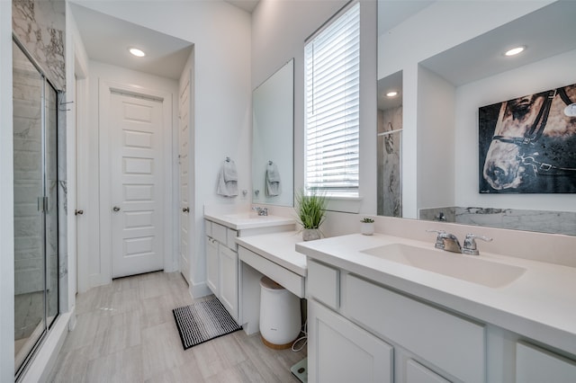 bathroom with a shower with door and vanity