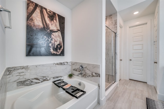 bathroom featuring shower with separate bathtub