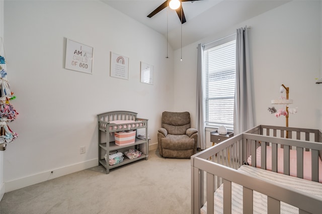 bedroom with a crib, carpet floors, and ceiling fan