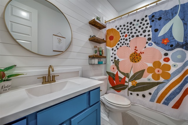 bathroom with vanity, wooden walls, and toilet