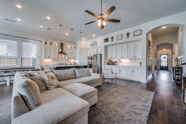 living room featuring ceiling fan, sink, and dark hardwood / wood-style flooring