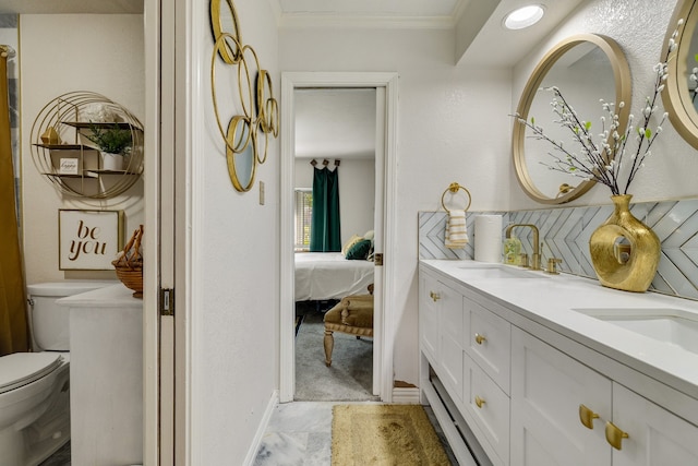 bathroom featuring ornamental molding, vanity, and toilet