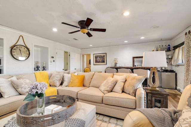 living room with ceiling fan, light hardwood / wood-style flooring, and ornamental molding