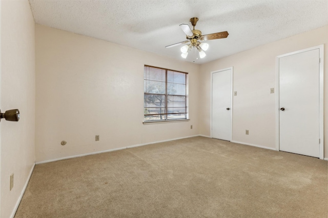 unfurnished room featuring light carpet, ceiling fan, and a textured ceiling