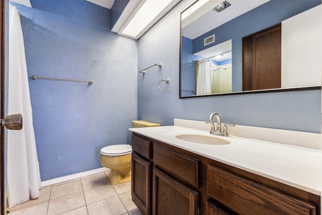 bathroom with tile patterned flooring, vanity, and toilet