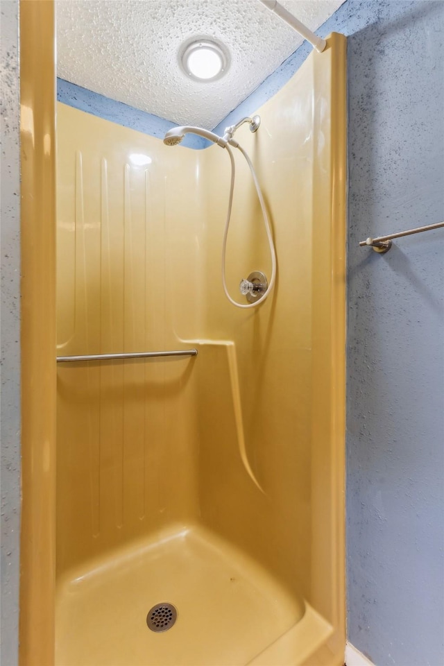 bathroom with a textured ceiling and walk in shower