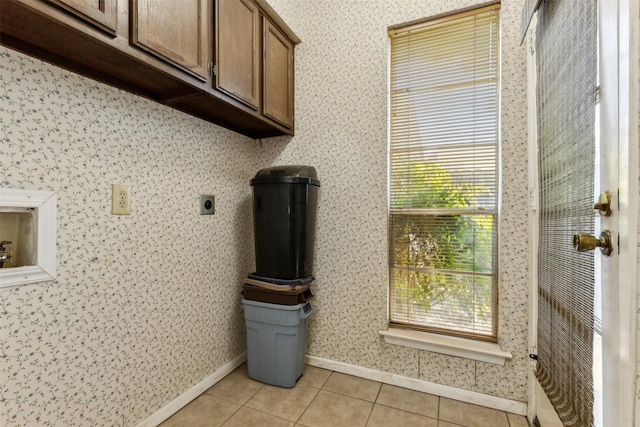 washroom featuring cabinets, hookup for an electric dryer, and light tile patterned floors