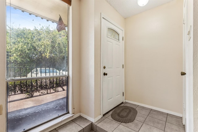 entryway with light tile patterned floors and a textured ceiling