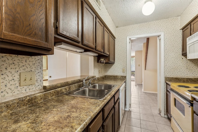 kitchen featuring light tile patterned flooring, sink, white appliances, dark brown cabinets, and a textured ceiling