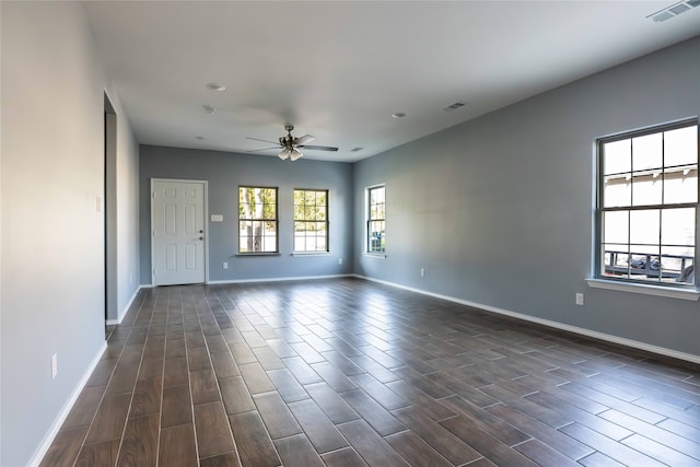 empty room with ceiling fan and dark hardwood / wood-style floors