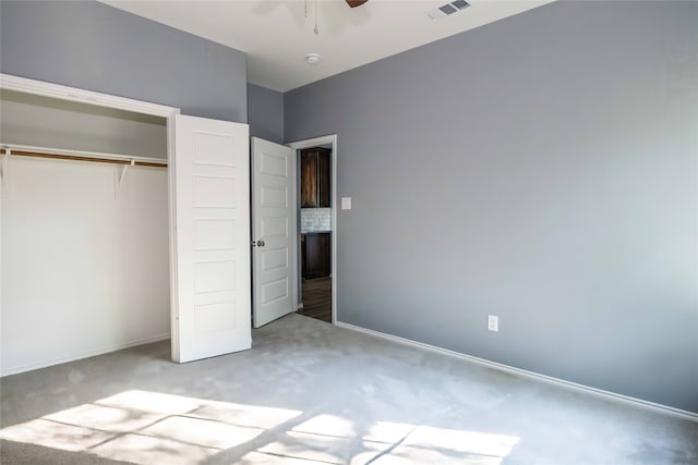 unfurnished bedroom with carpet floors, a closet, and ceiling fan