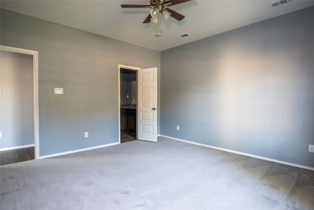 unfurnished room with dark carpet and ceiling fan