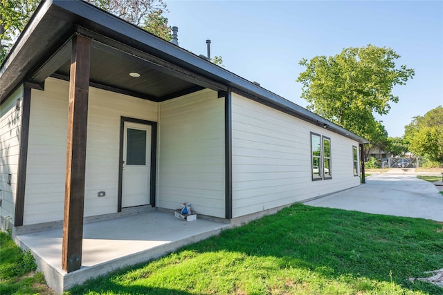 rear view of house featuring a lawn and a patio area