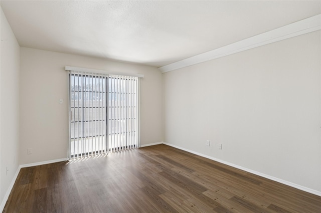 spare room with dark wood finished floors and baseboards