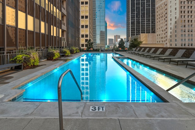 pool at dusk featuring a patio area