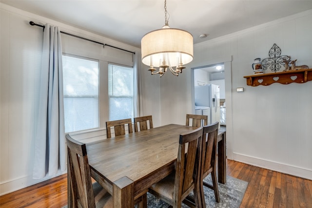 dining room featuring ornamental molding, a notable chandelier, and dark wood-type flooring