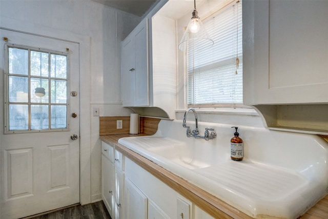 interior space with white cabinets, hanging light fixtures, and dark hardwood / wood-style flooring