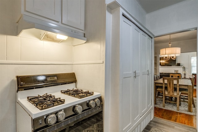 kitchen with white range with gas stovetop, crown molding, and light hardwood / wood-style floors