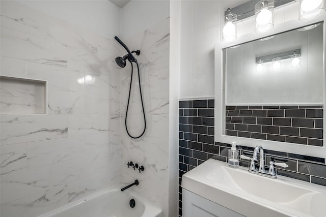 bathroom featuring tile walls, vanity, and tiled shower / bath combo