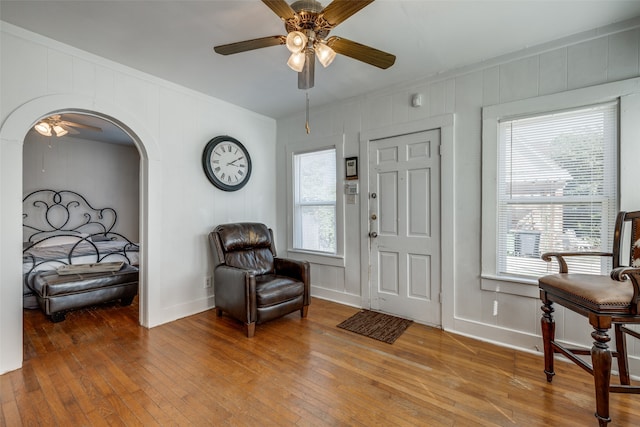 living area featuring crown molding, ceiling fan, and hardwood / wood-style floors