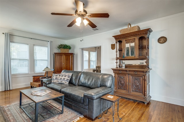 living room with ornamental molding, light hardwood / wood-style flooring, and ceiling fan