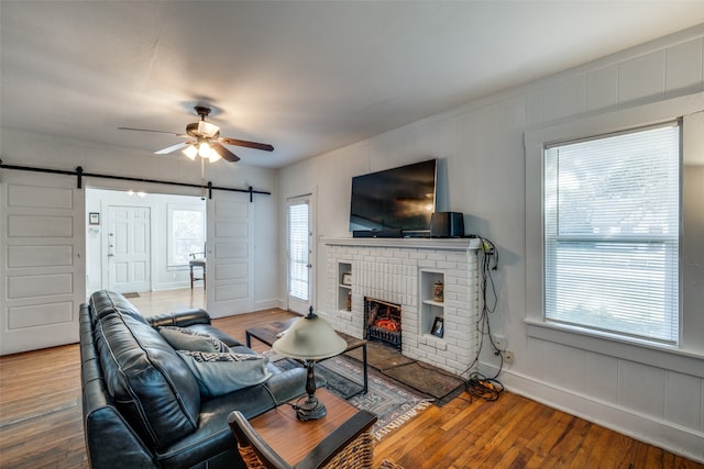 living room featuring hardwood / wood-style flooring, a barn door, and a healthy amount of sunlight