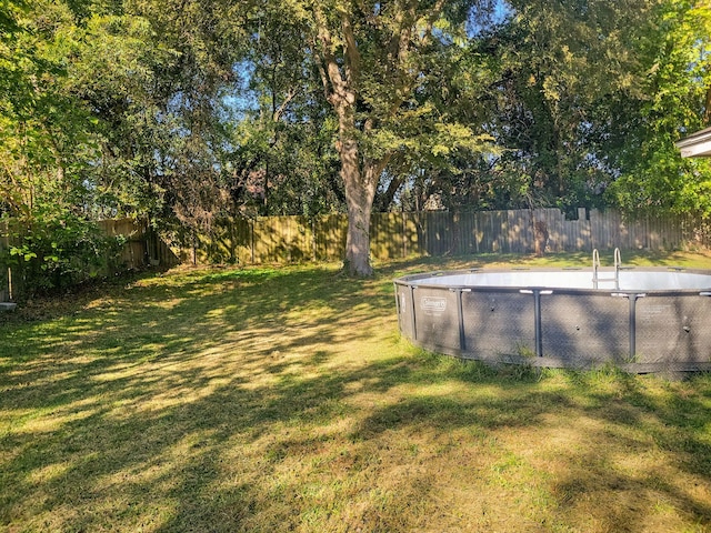 view of yard with a fenced in pool