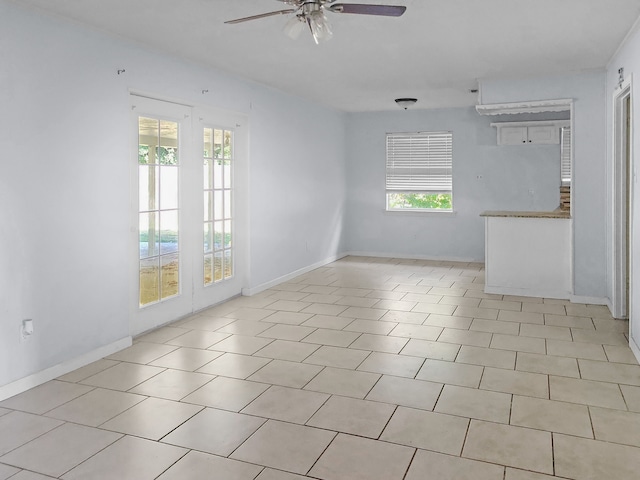 tiled empty room featuring ceiling fan