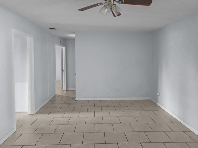 tiled spare room with ceiling fan