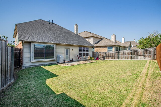 rear view of house with a yard and a patio