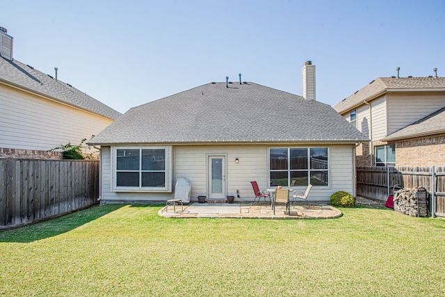 rear view of house with a patio and a lawn