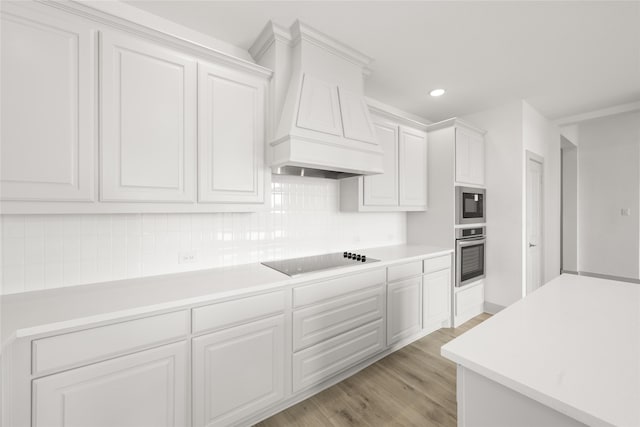 kitchen featuring decorative backsplash, white cabinetry, light wood-type flooring, and black electric cooktop