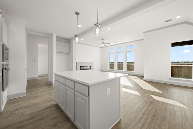 kitchen with stainless steel appliances, a wealth of natural light, light wood-type flooring, and a kitchen island