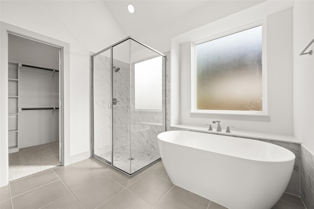 bathroom featuring tile patterned flooring and separate shower and tub