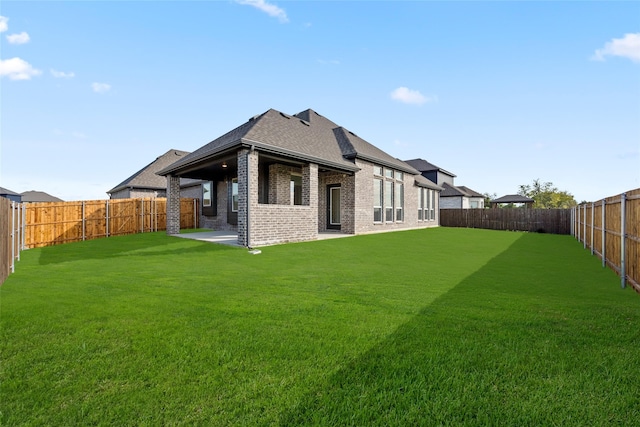 back of property with a yard and a patio