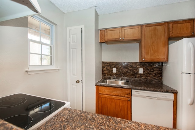 kitchen with a textured ceiling, white appliances, sink, and tasteful backsplash