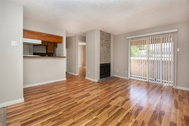 unfurnished living room featuring a textured ceiling and light wood-type flooring