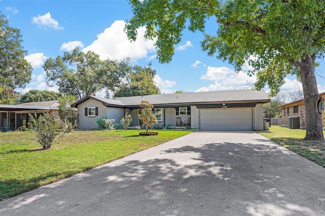 ranch-style home featuring a front yard, cooling unit, and a garage