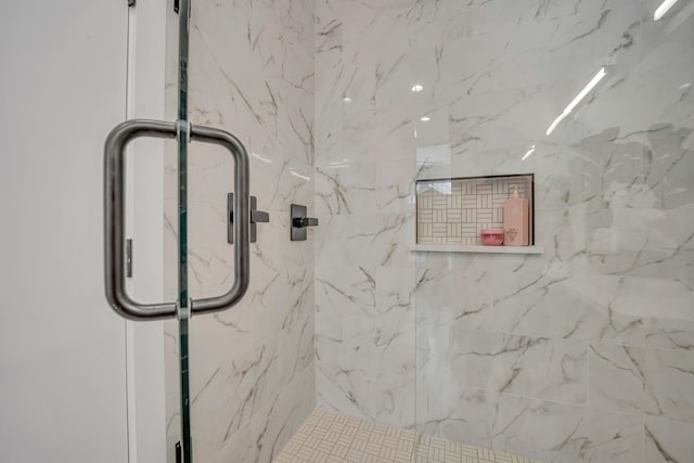 interior details featuring a marble finish shower