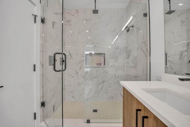 full bathroom with a marble finish shower and vanity