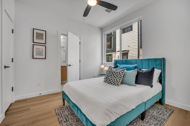 bedroom featuring baseboards, visible vents, ceiling fan, and light wood finished floors