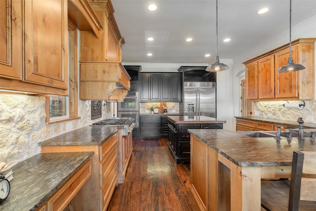 kitchen featuring dark wood-type flooring, pendant lighting, a kitchen bar, a kitchen island with sink, and ornamental molding