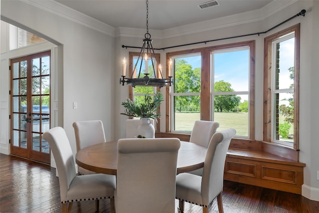 dining space with dark hardwood / wood-style floors, plenty of natural light, crown molding, and a chandelier