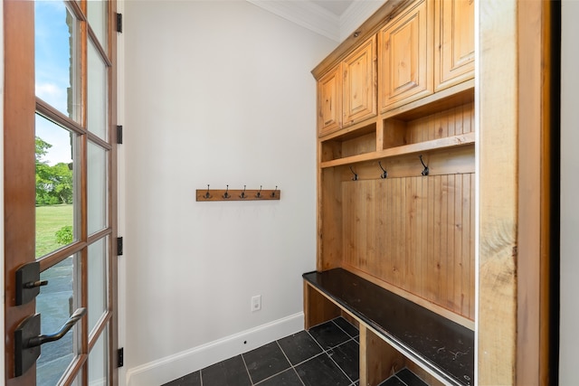 mudroom featuring dark tile patterned floors and ornamental molding