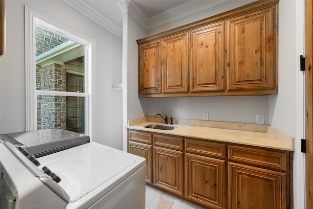 kitchen with washer and clothes dryer, sink, and ornamental molding